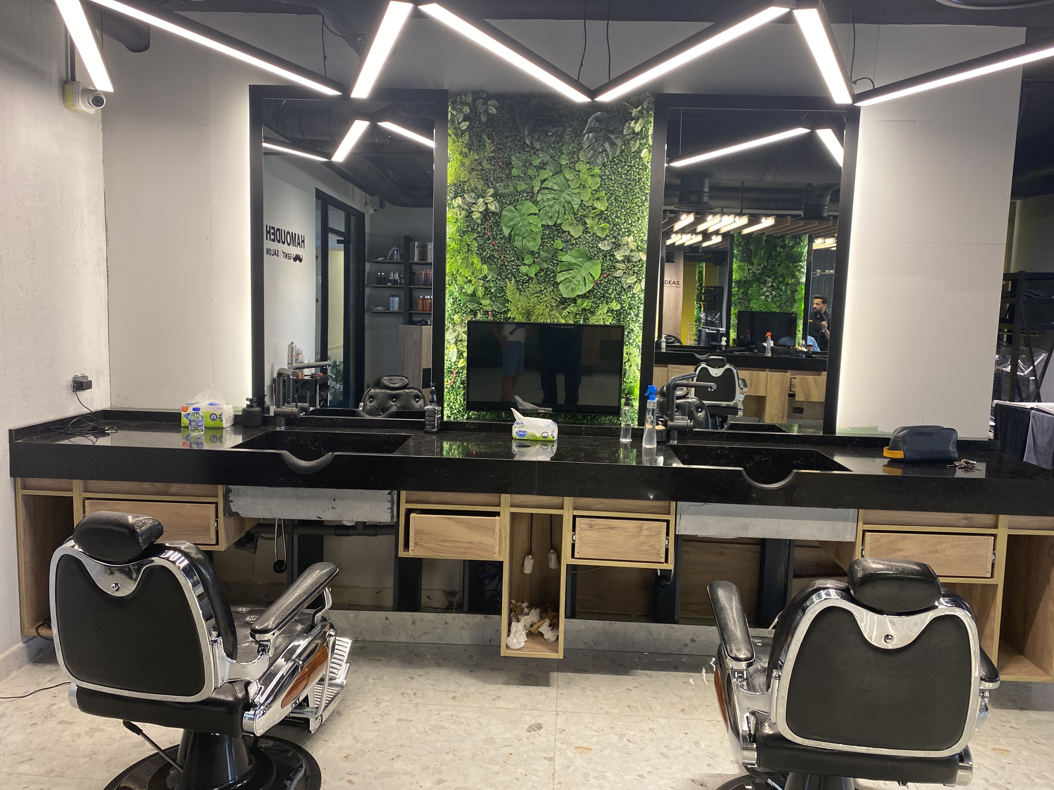Hamoudeh Gent's Salon styling floor with a living green wall and zigzag LED ceiling